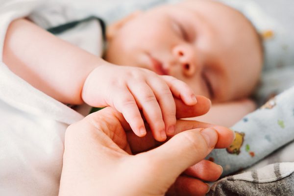 cute-newborn-baby-holding-mothers-hand-while-sleep